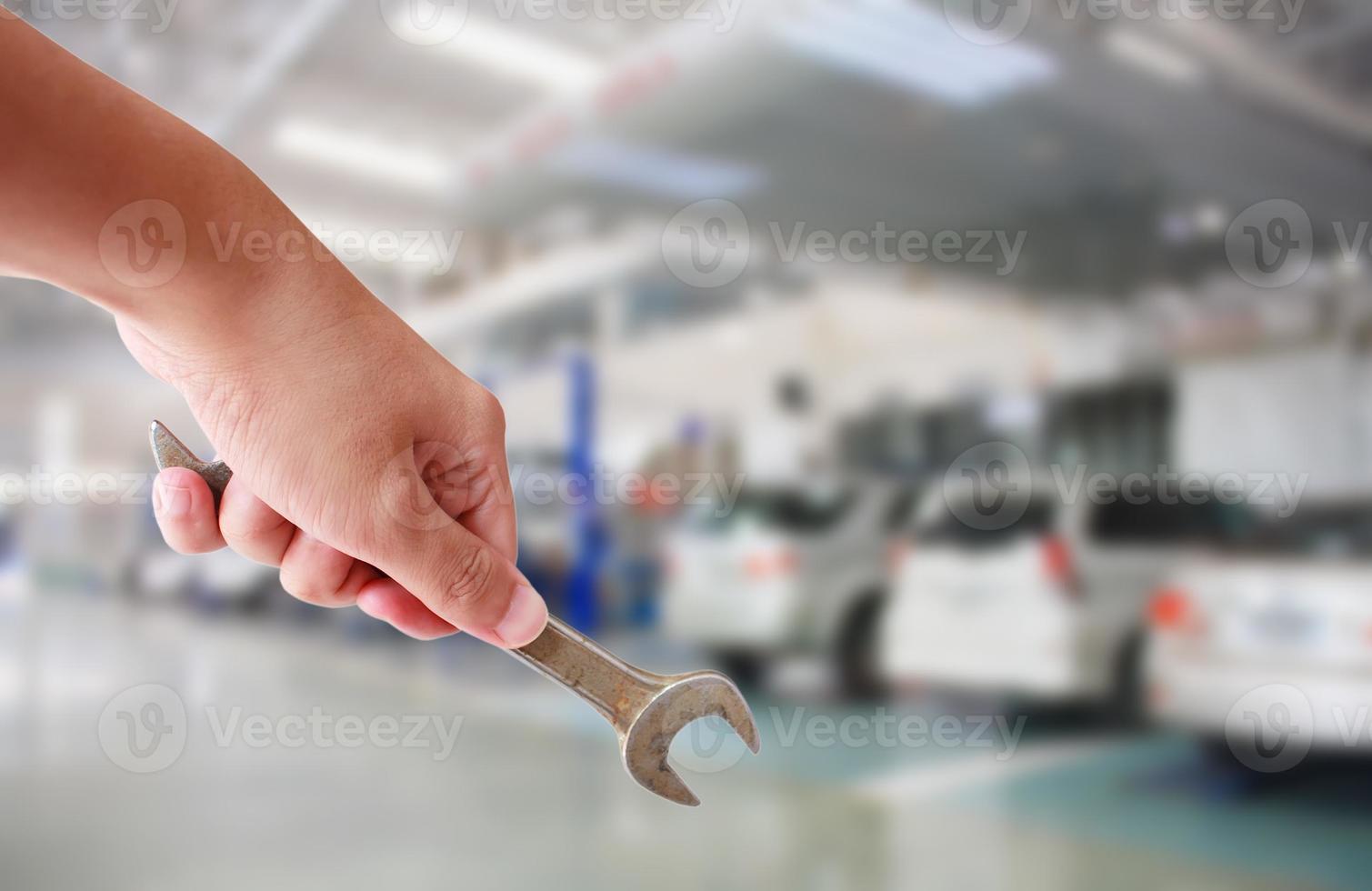 técnico sosteniendo llave con de centro de servicio de reparación de automóviles 7199018 Foto de stock en Vecteezy