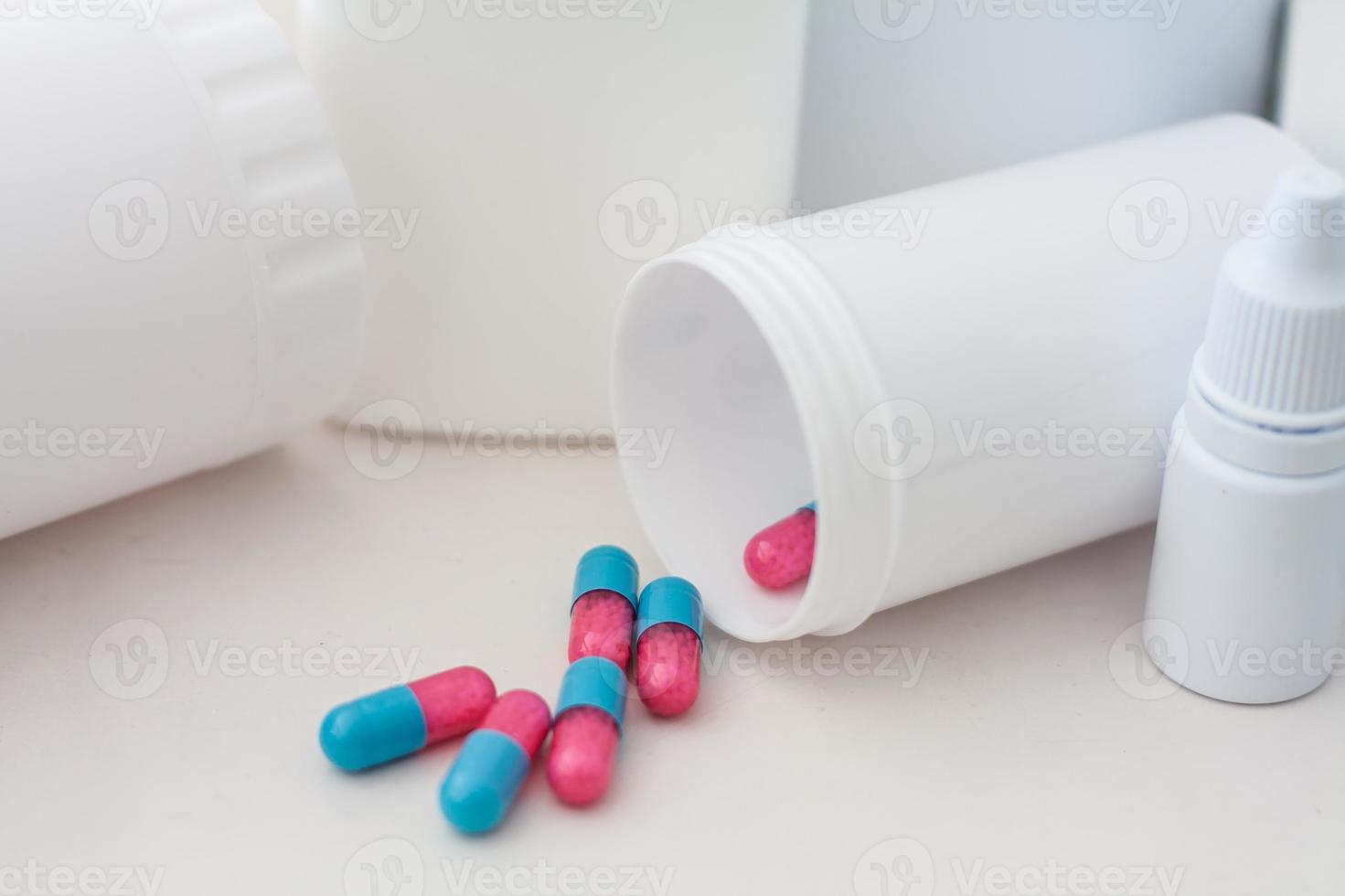 Pills spilling out of pill bottle with medicine background photo