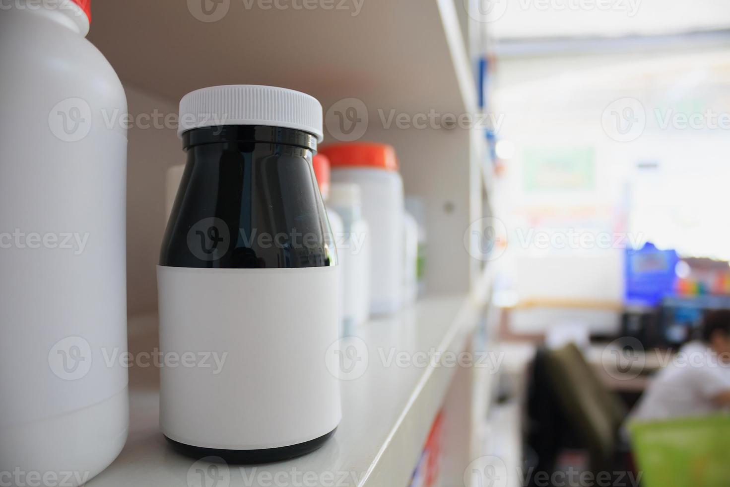 medicine bottles arranged on shelf at drugstore photo