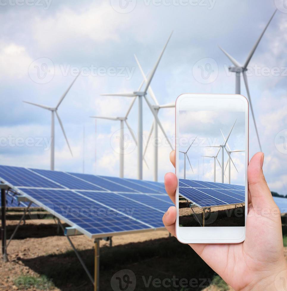 paneles solares y turbinas de viento con las nubes y el cielo foto