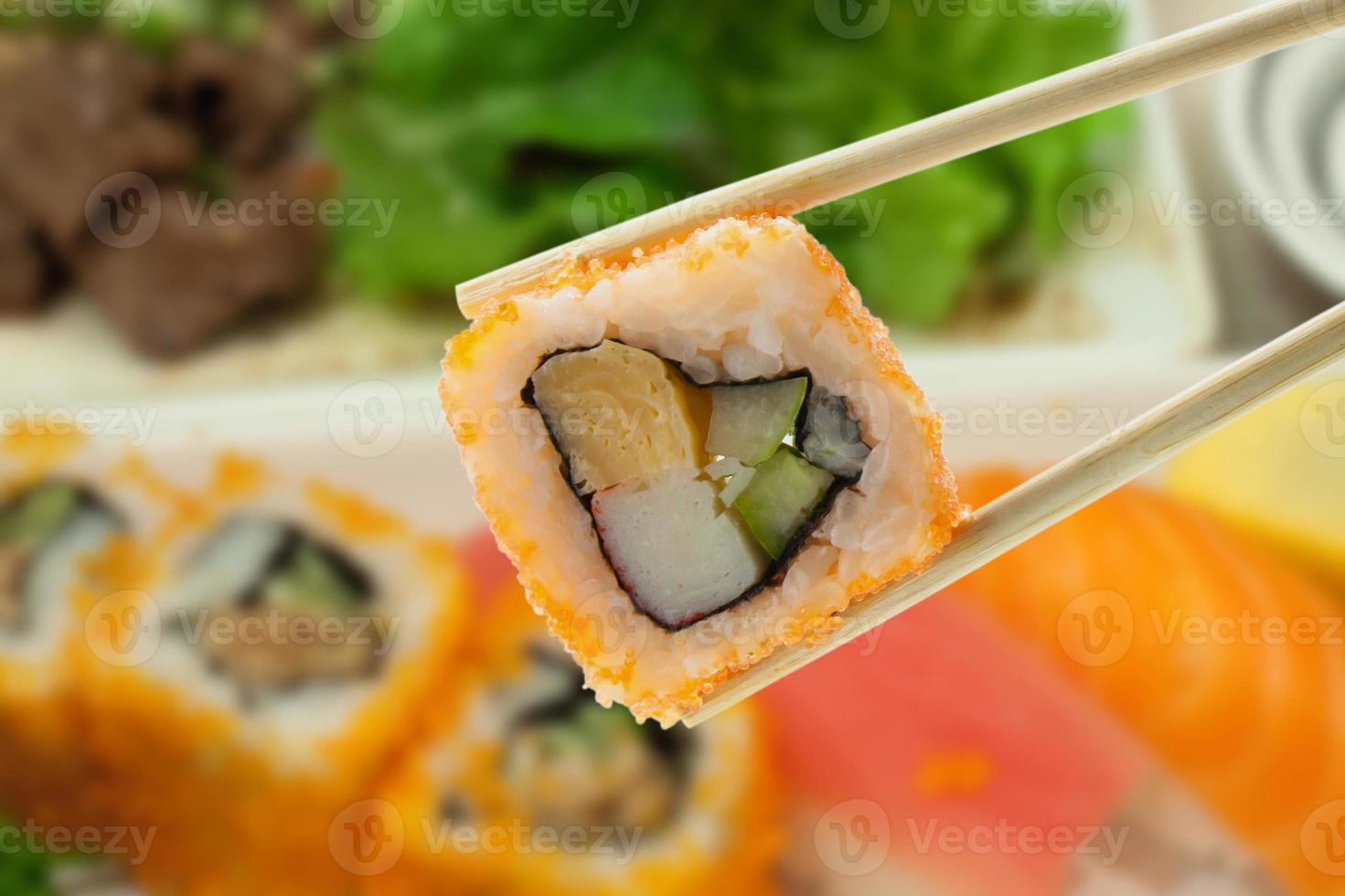 rollo de sushi con palillos foto