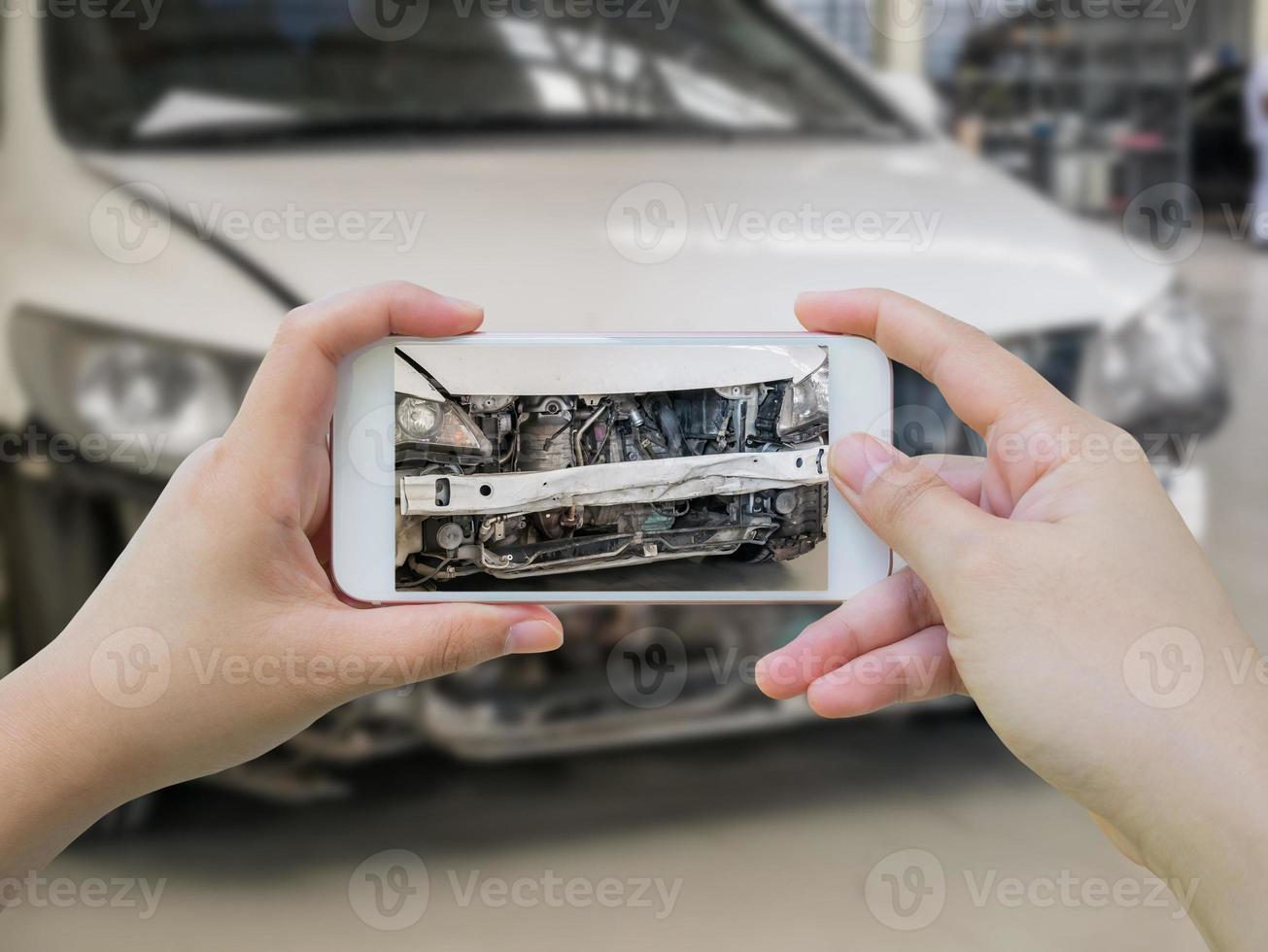 Hembra sostenga teléfono inteligente móvil fotografiando accidente automovilístico foto