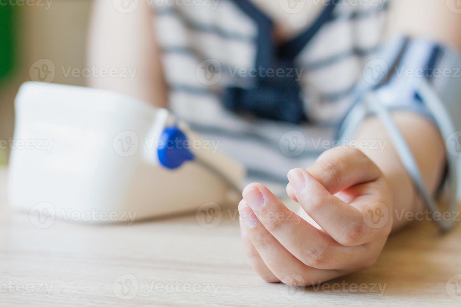 Woman using digital blood pressure monitor photo