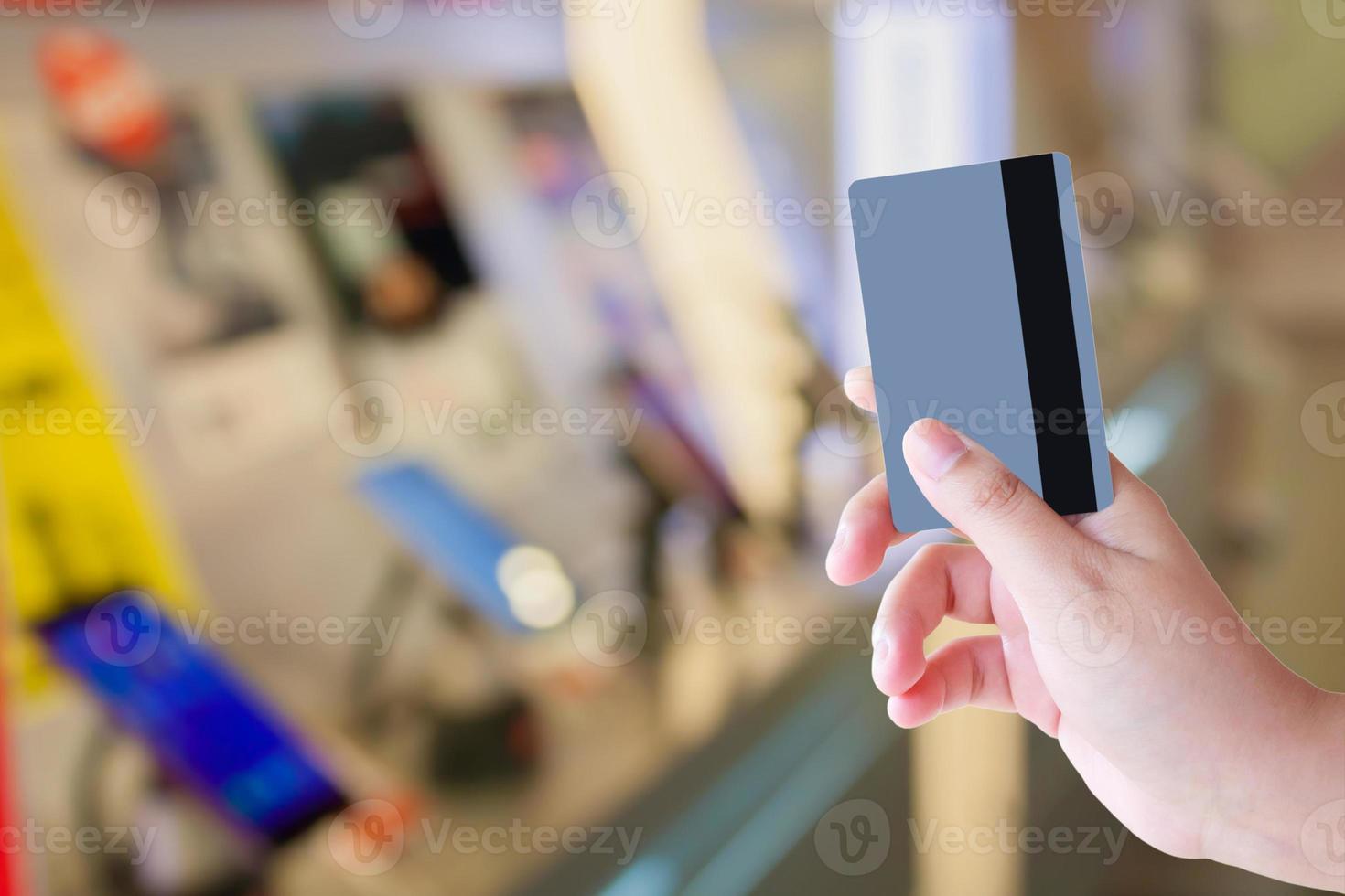 mano que sostiene la tarjeta de crédito en la tienda de teléfonos móviles foto