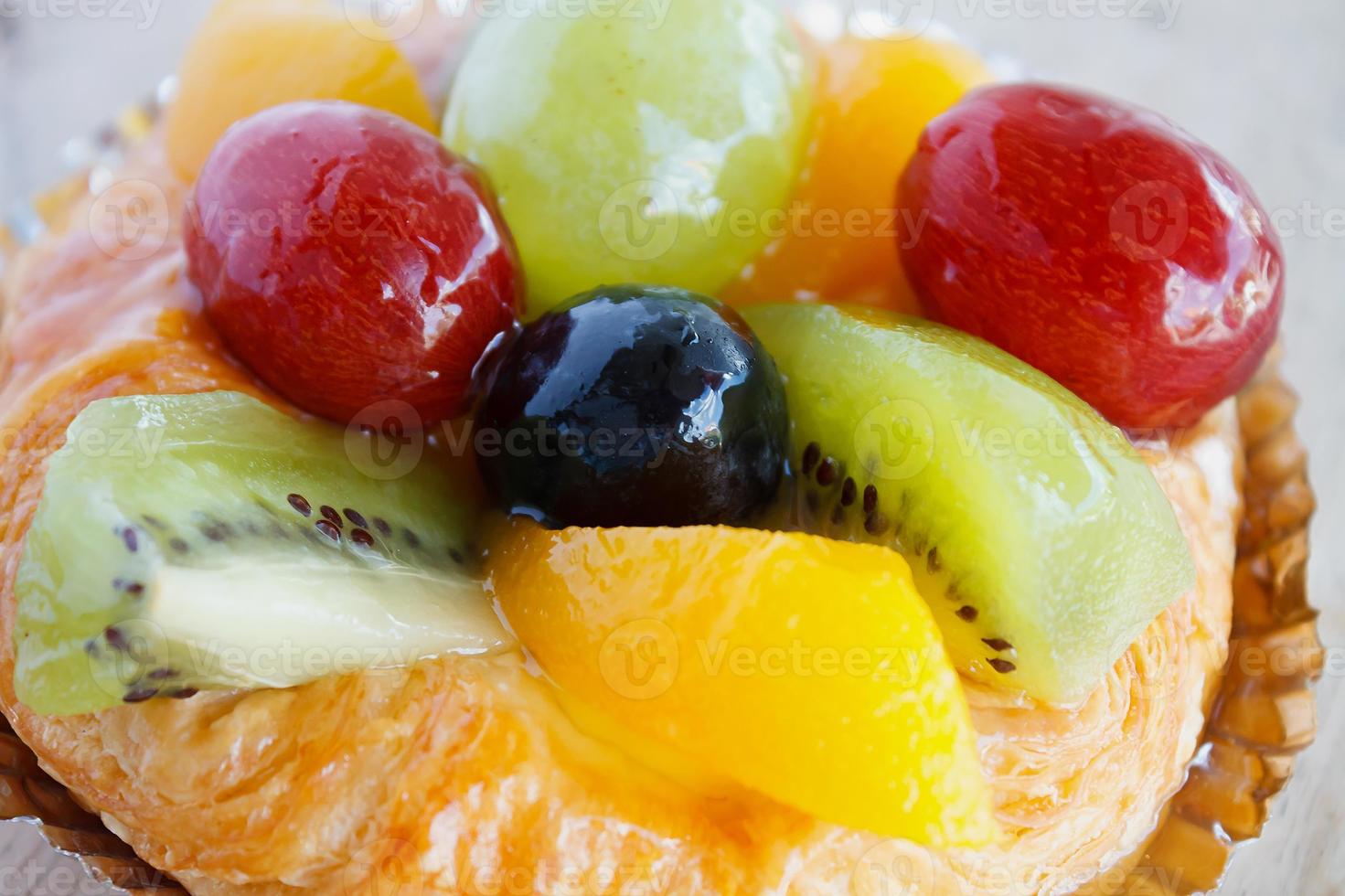 close up danish pastry with fruit on wood table photo