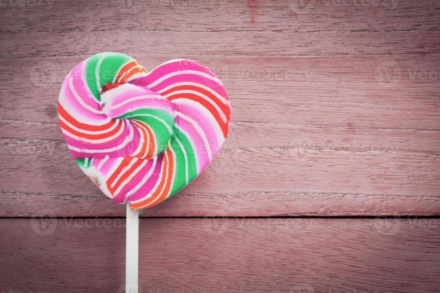 colorful heart lollipop on wood background photo