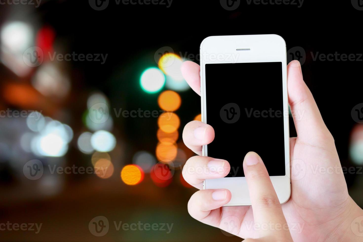 Business concept, hand holding mobile with traffic light blurred background photo