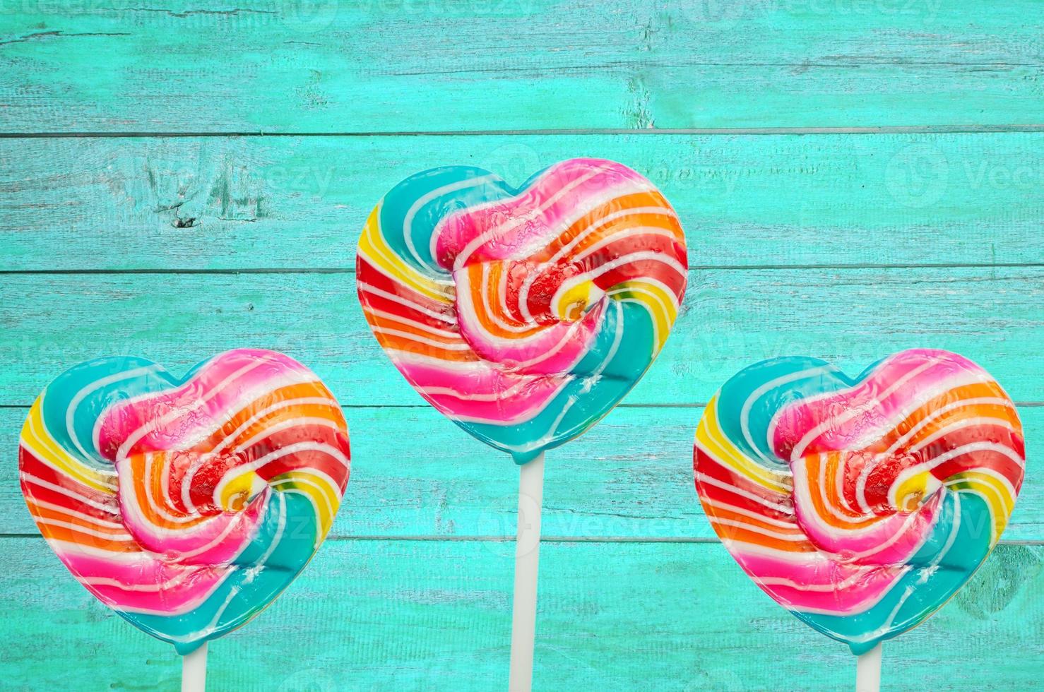 colorful heart lollipop on vintage color wood background photo