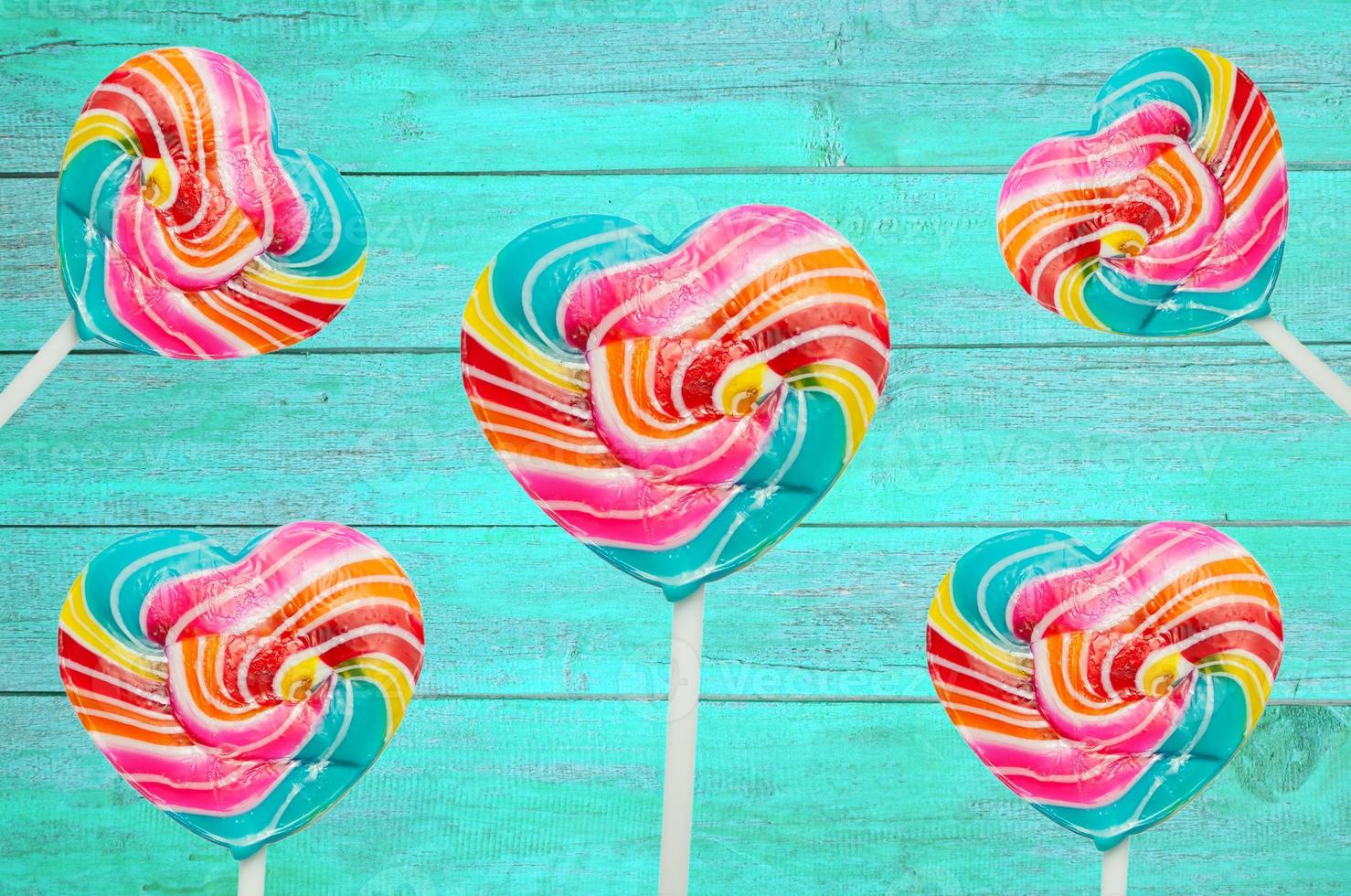 colorful heart lollipop on vintage color wood background photo