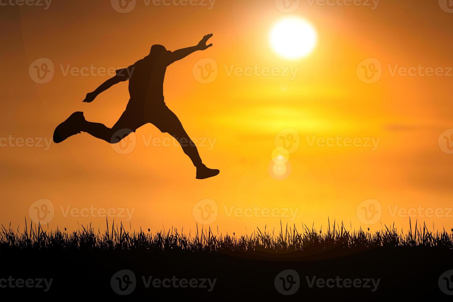 The silhouette of a man is jumping forward. The concept of clawing through hurdles photo