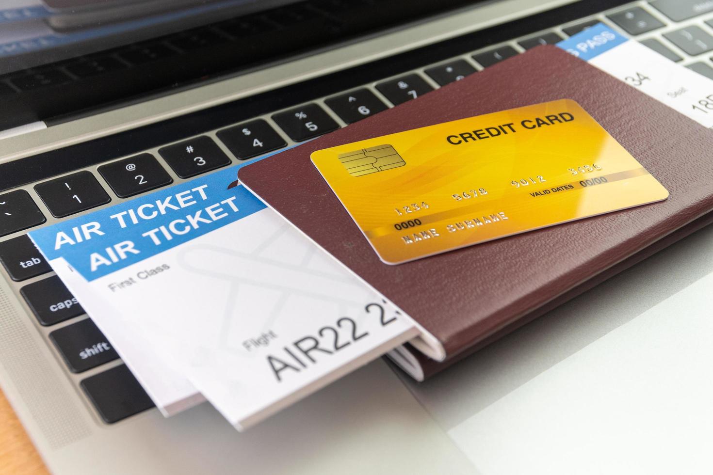 Credit card and passports near laptop computer on table. Online ticket booking concept photo