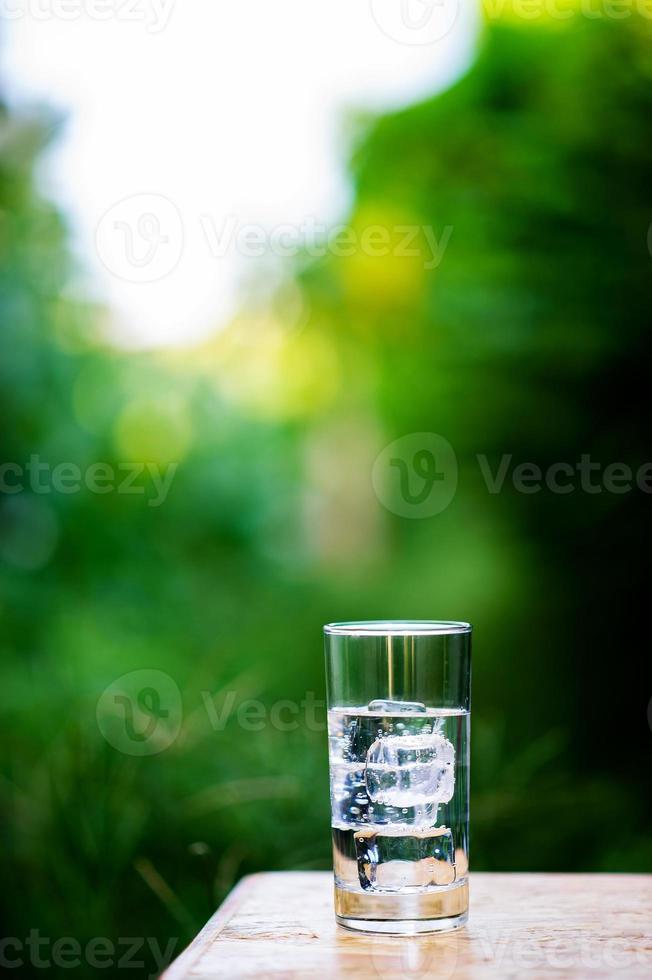 A glass of clean water with ice placed on the table ready to drink photo