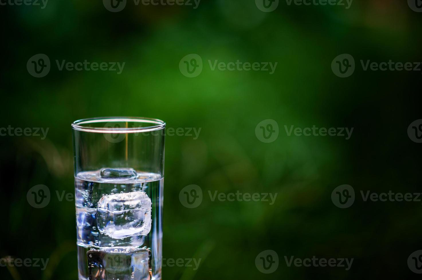 A glass of clean water with ice placed on the table ready to drink photo