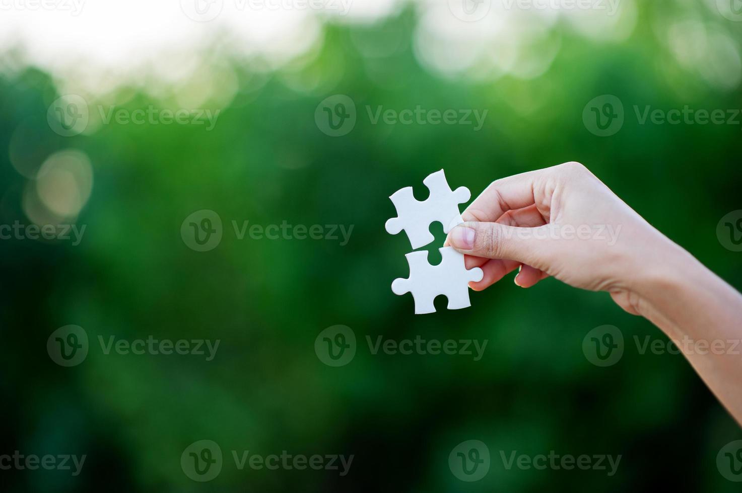 Hands and white jigsaw puzzles Close-up image and integration Business concept and unity photo