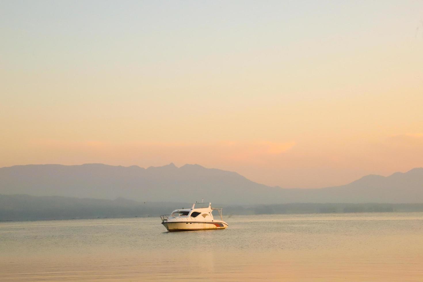 Beautiful Background with Ship at sunrise with golden clouds in Lake Toba photo
