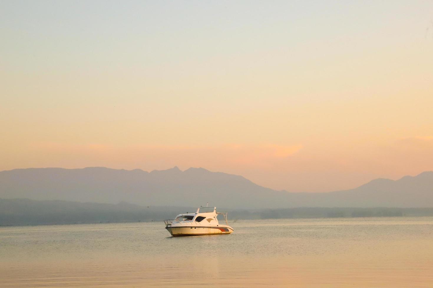 Beautiful Background with Ship at sunrise with golden clouds in Lake Toba photo