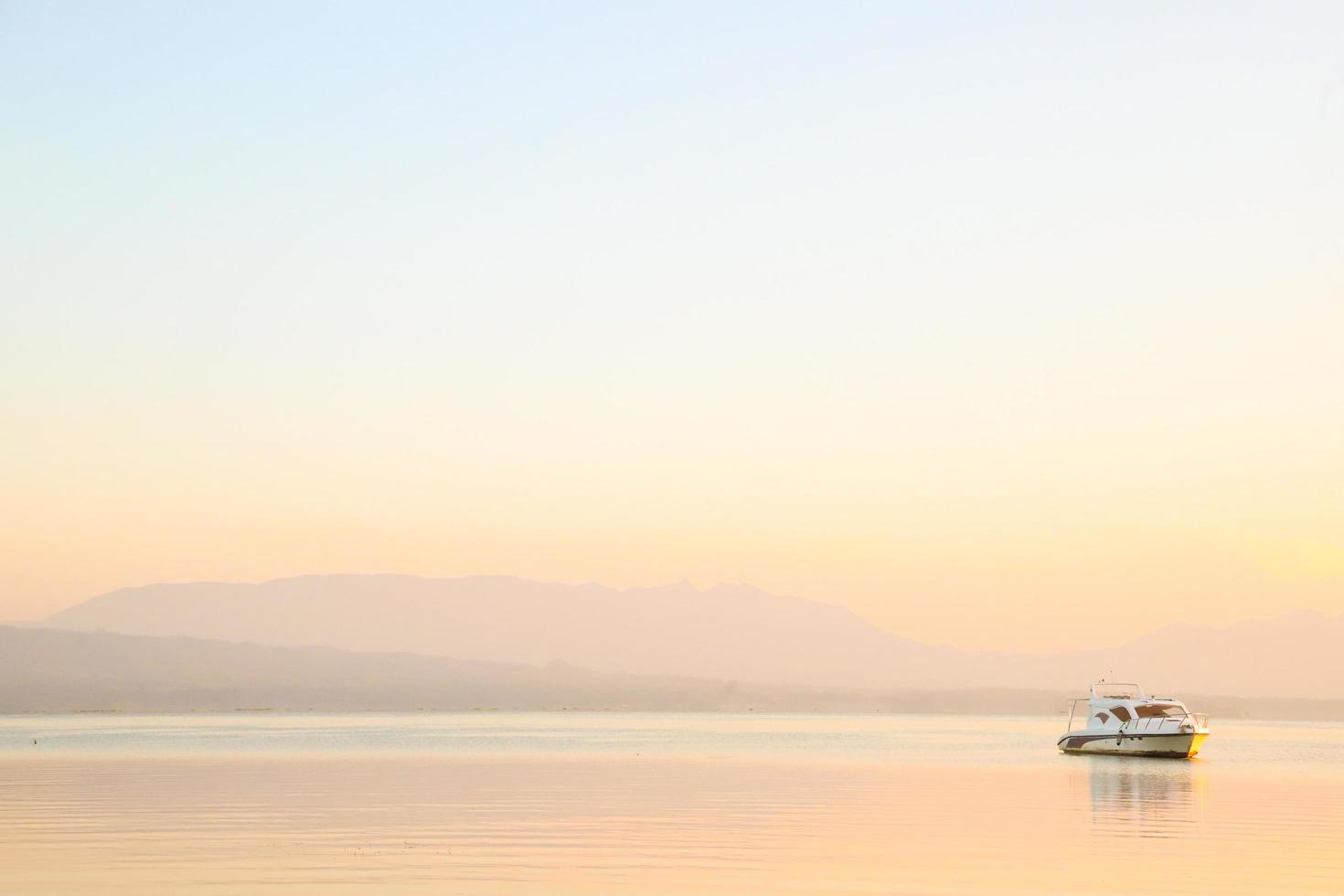 Lake boat at orange sunset background in Toba Lake photo