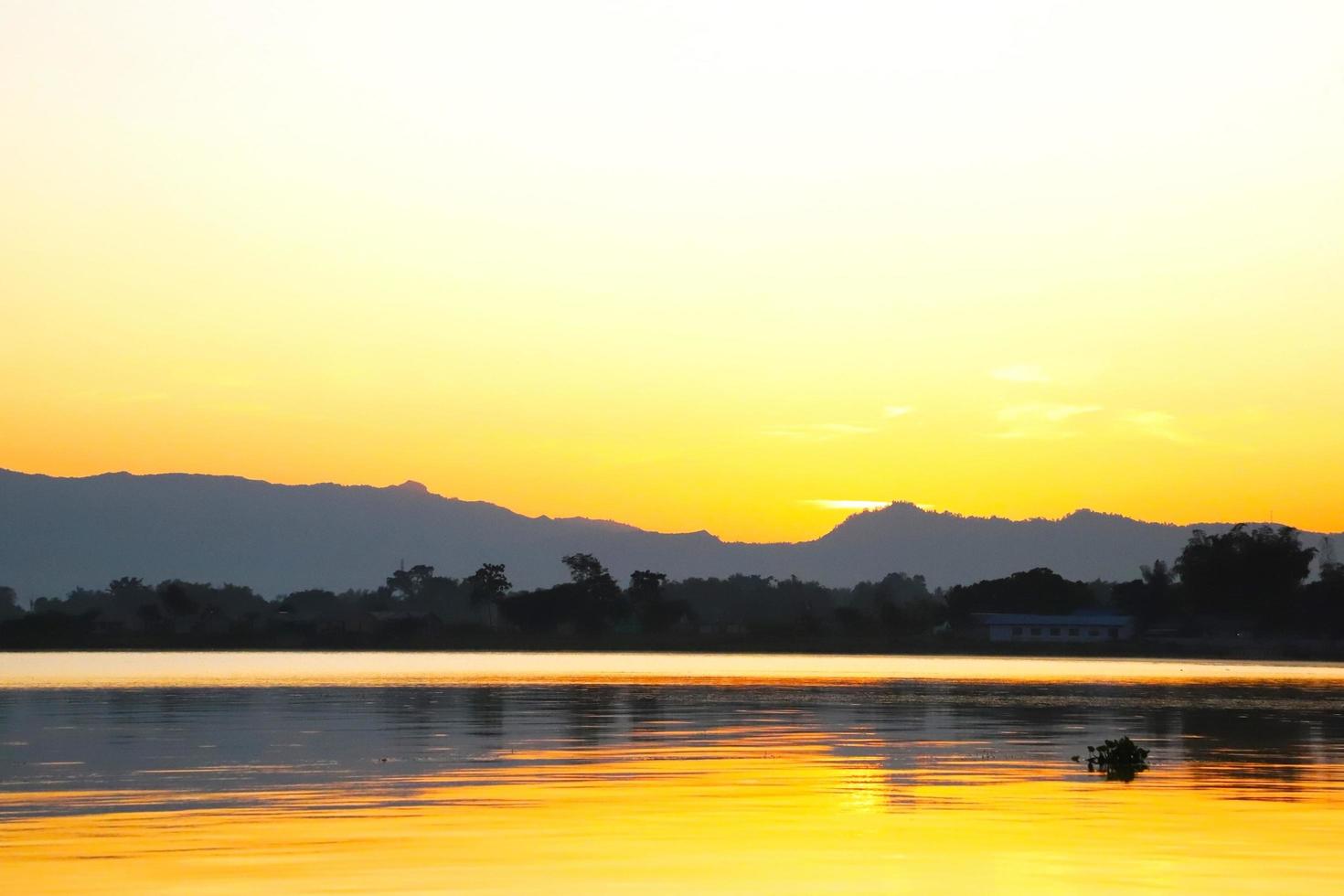 Majestic real sunrise background in lake toba with golden clouds photo