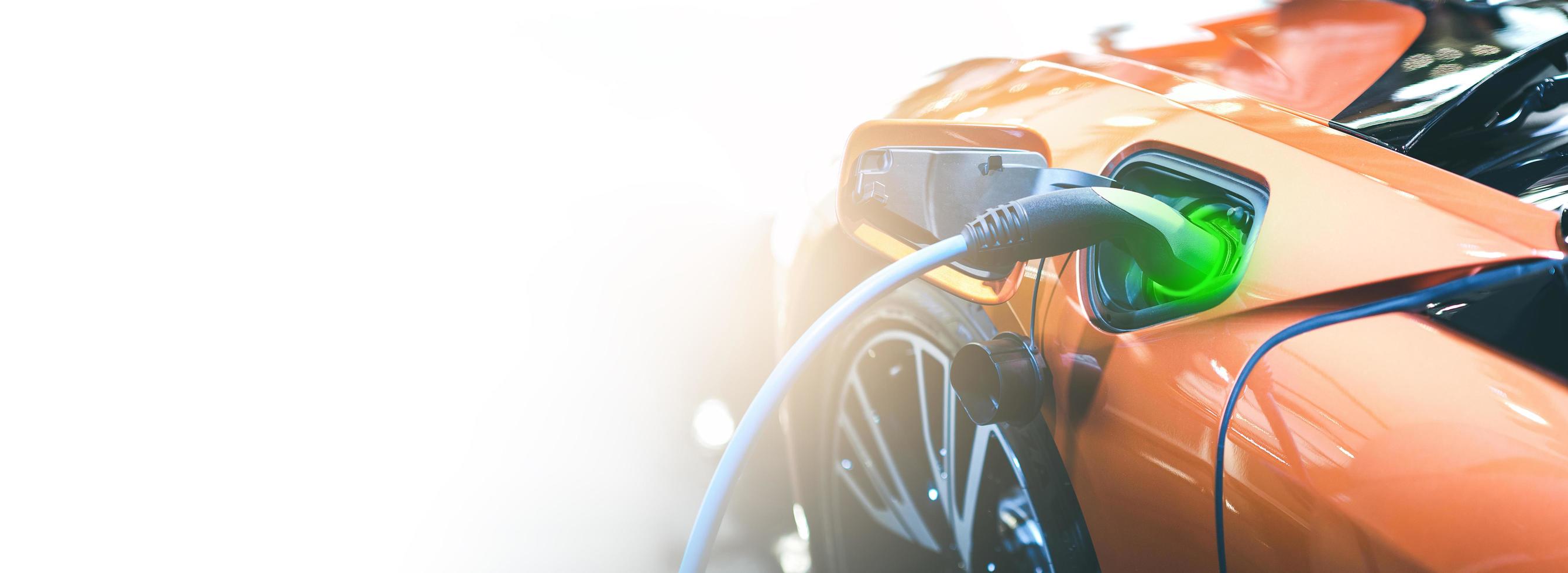 eléctrico ev coche naranja carga batería energía en la estación. banner web panorámico sobre fondo blanco con concepto de espacio de copia. foto