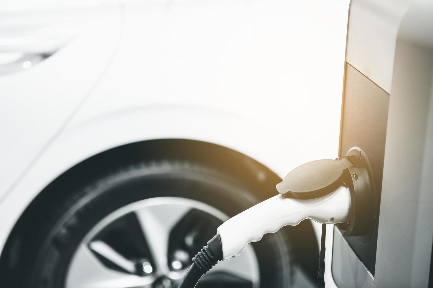 coche eléctrico ev cargando energía de la batería en la estación. foto