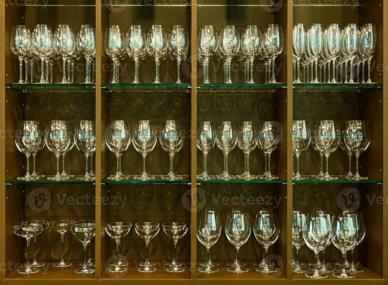 Set of glasses for different alcoholic drinks and cocktails on wood shelf background. photo