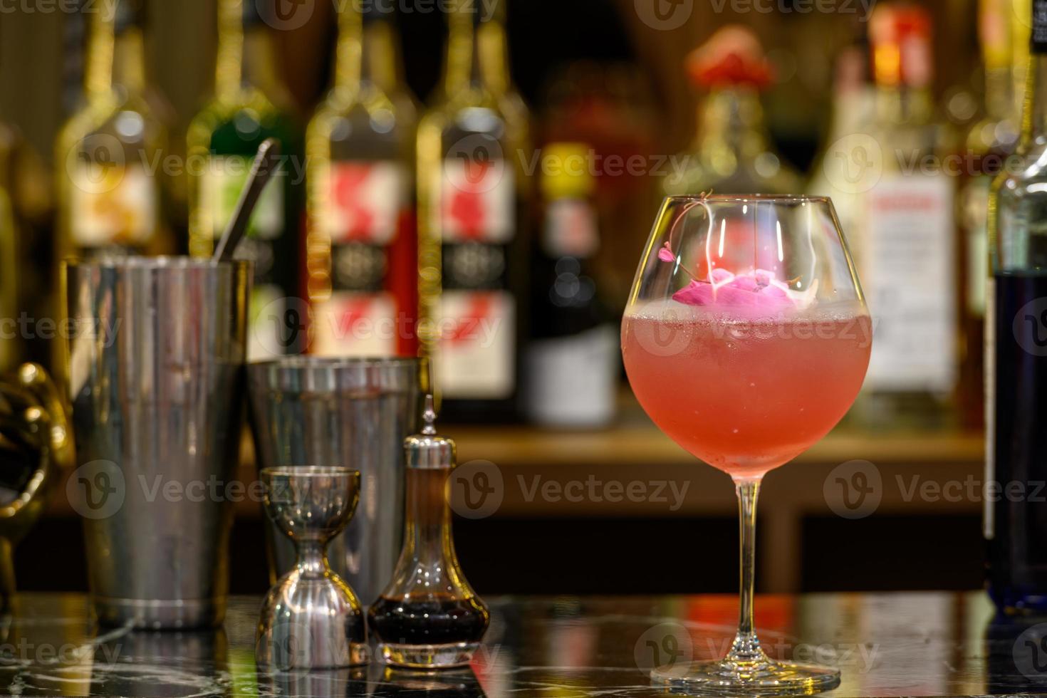 vaso fresco de cóctel tropical con jugo en el fondo desenfocado del mostrador del bar. foto