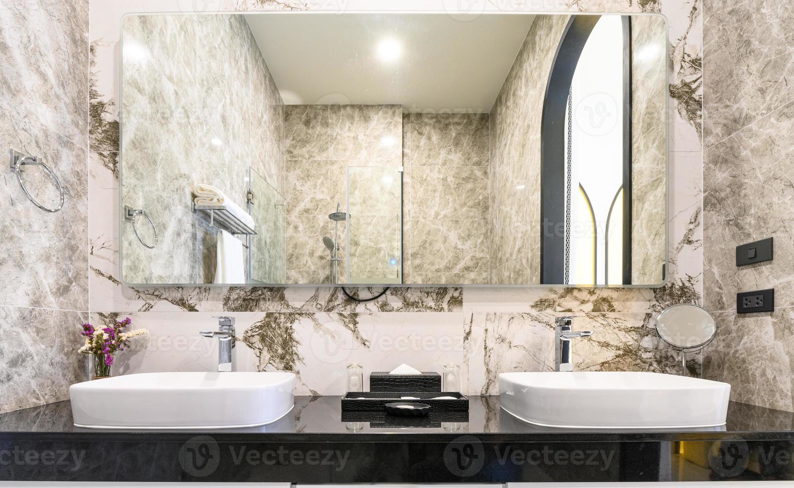 Modern style interior design of a wash basin on black granite counter in restroom photo