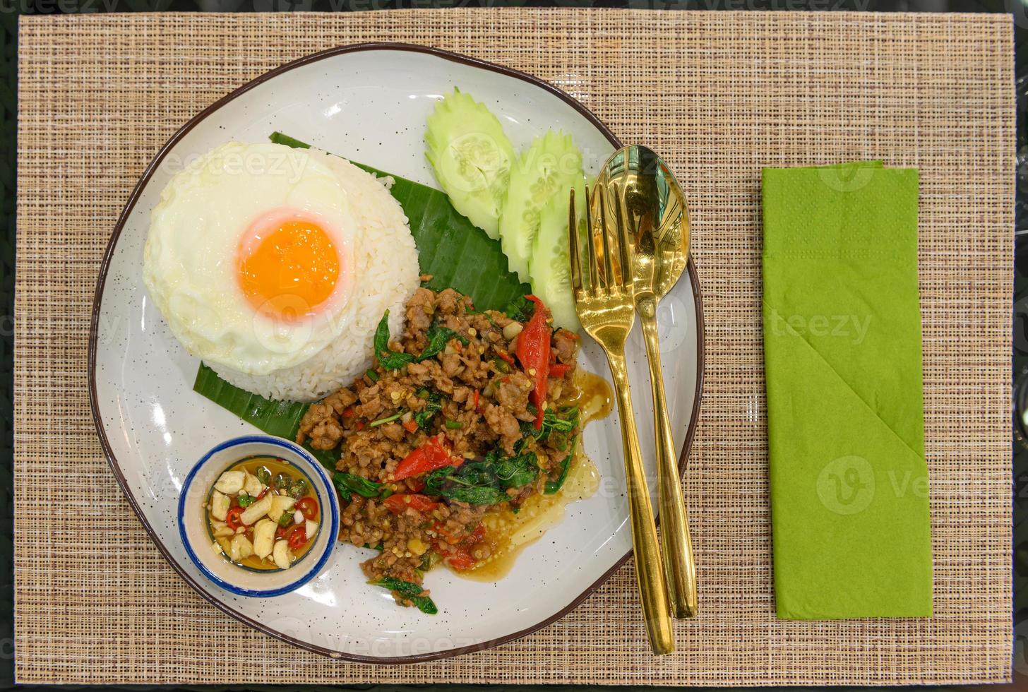 Stir fried Thai basil with minced pork and a fried egg on white plate photo