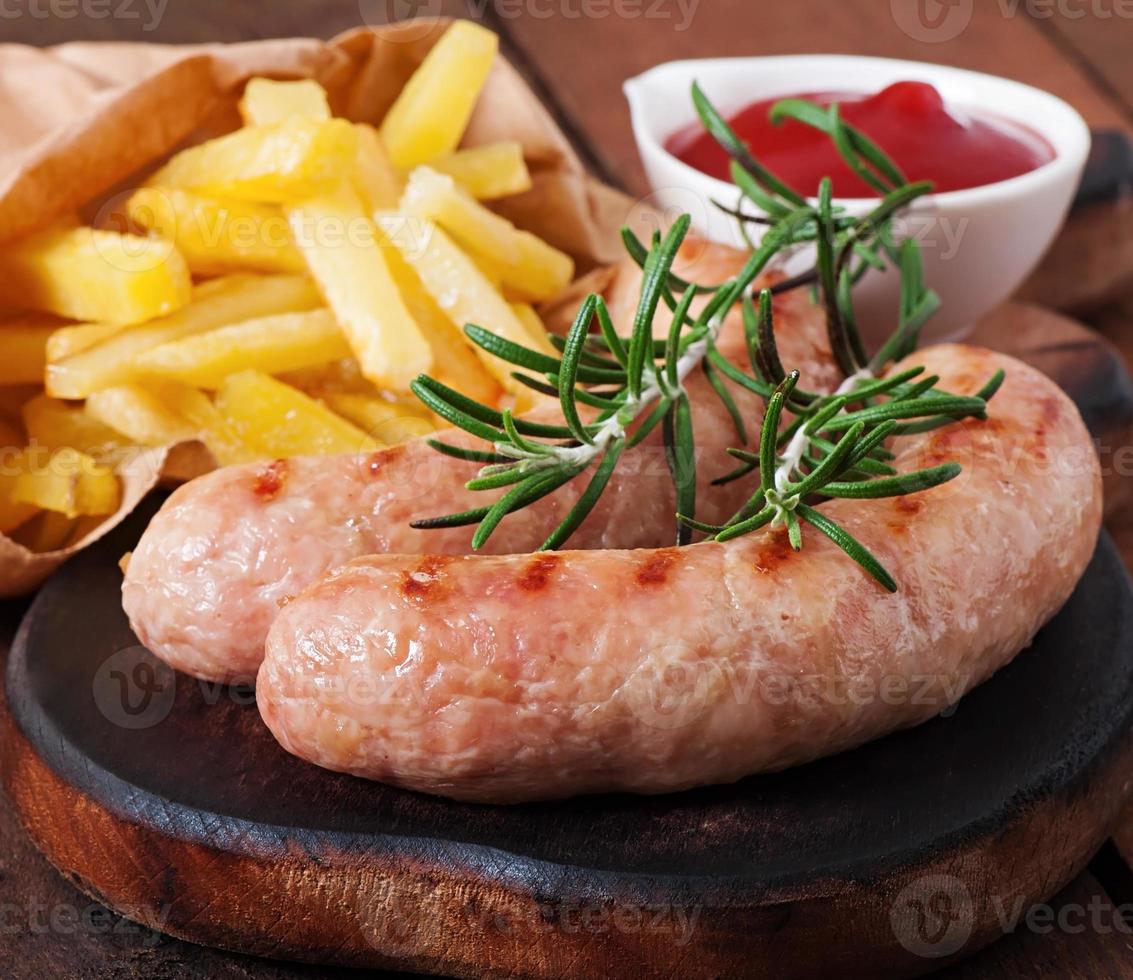 Chicken sausages grilled with a side dish of  french fries photo