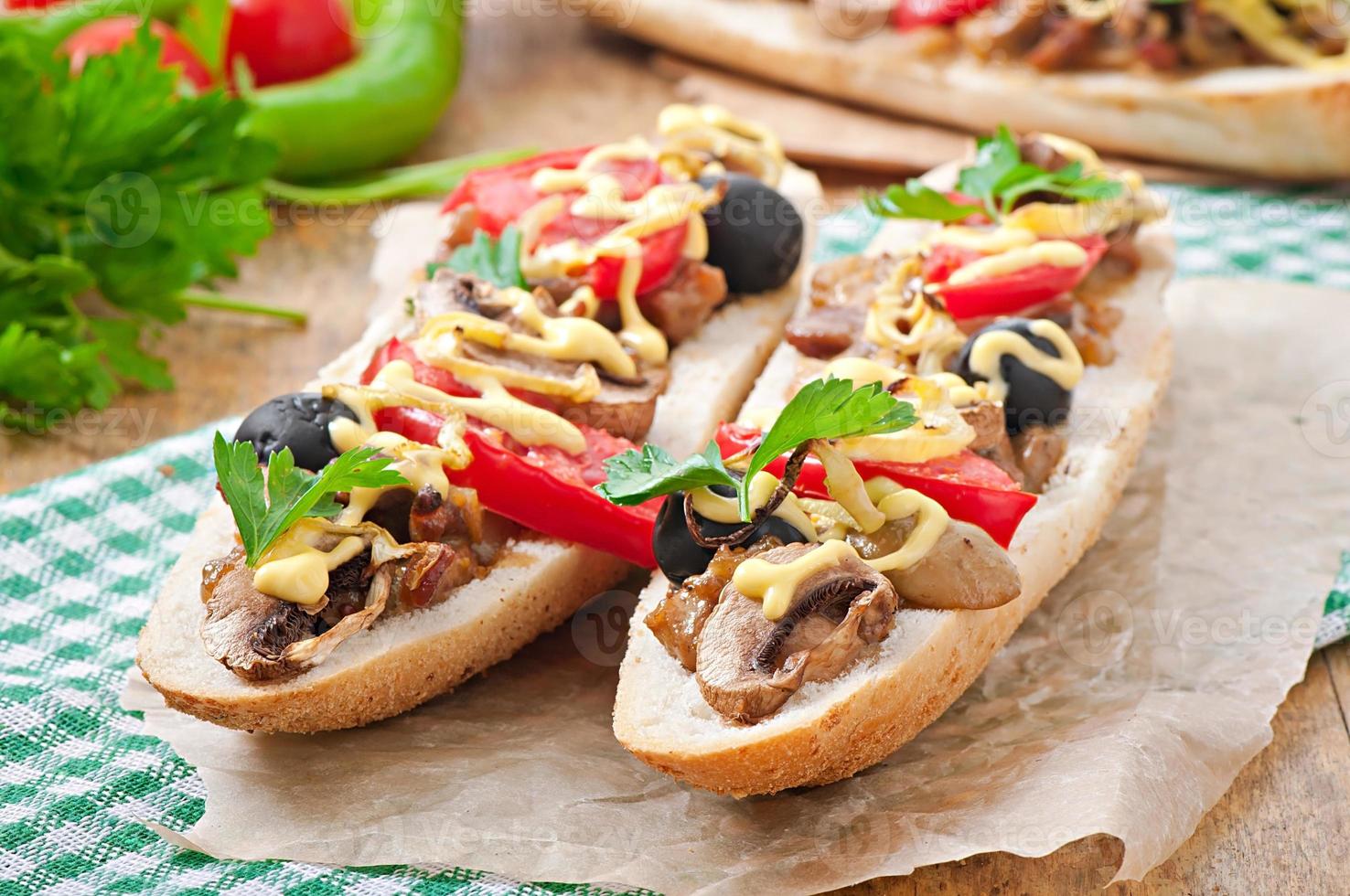 Baguette stuffed with veal and mushrooms with tomatoes and cheese photo