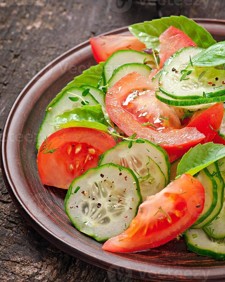 Tomato and cucumber salad with black pepper and basil photo