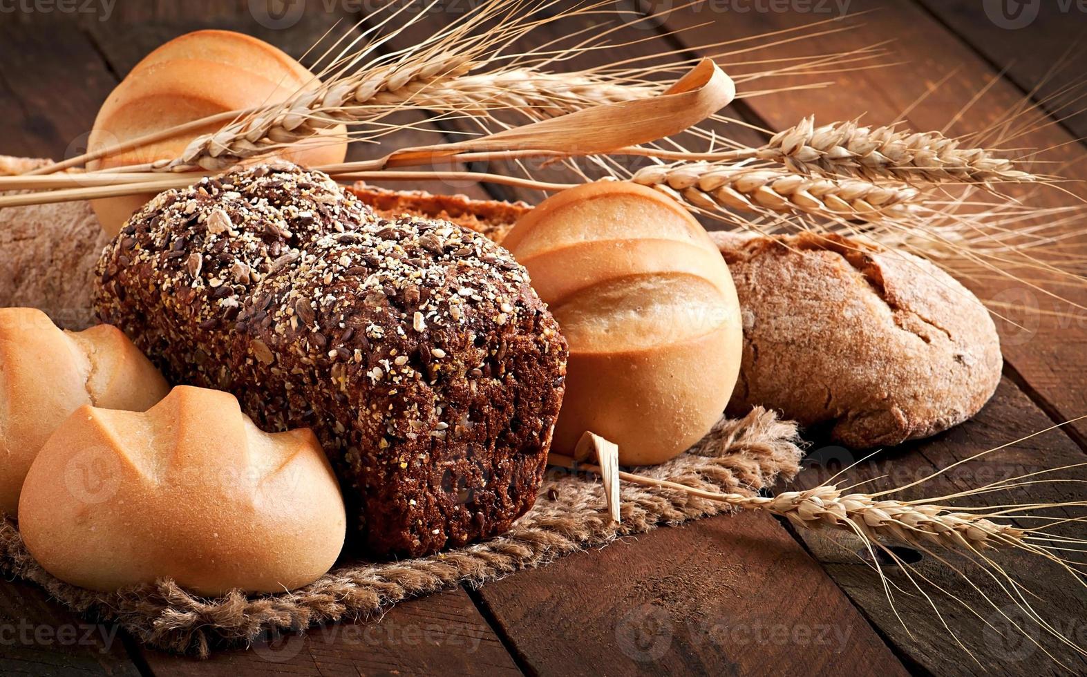 Assortment of baked bread on a wooden table photo