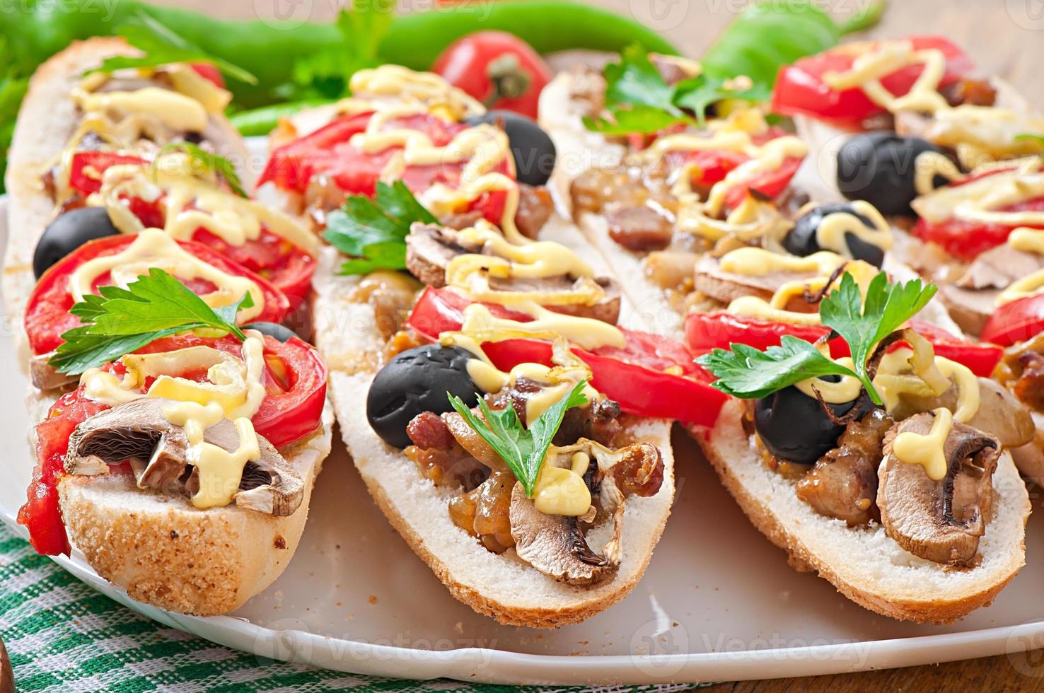 Baguette stuffed with veal and mushrooms with tomatoes and cheese photo