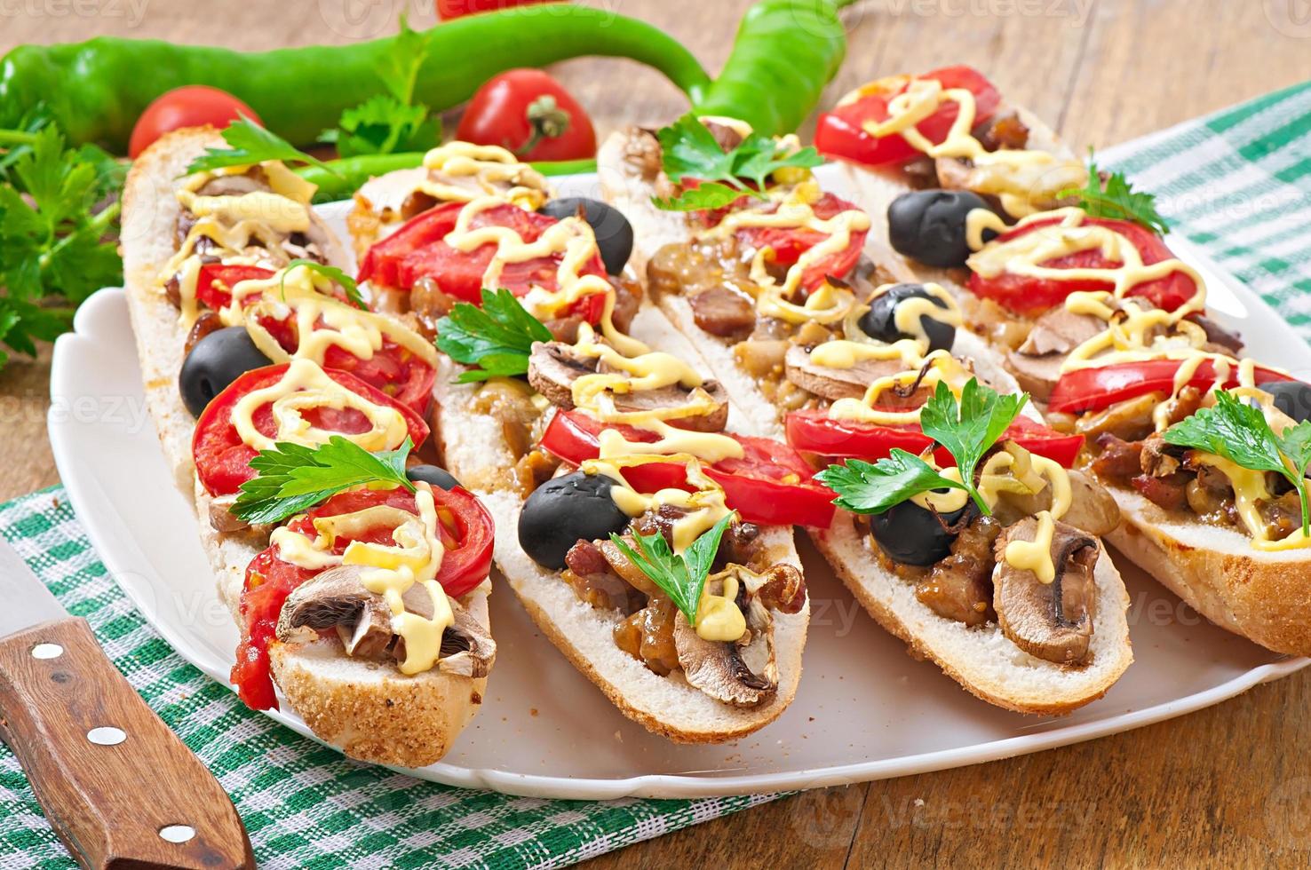 Baguette stuffed with veal and mushrooms with tomatoes and cheese photo