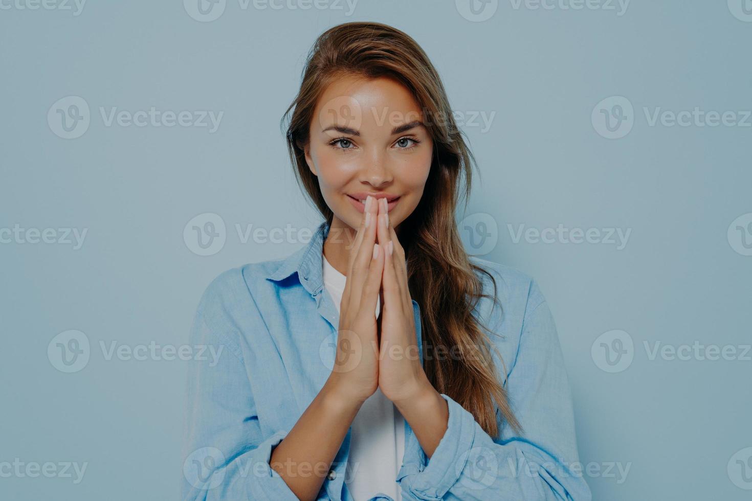 feliz calma agradecida modelo mujer doblando las manos para orar namaste gesto foto