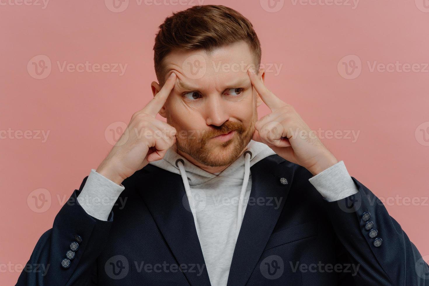 Man having doubts and making decision isolated over pink wall photo