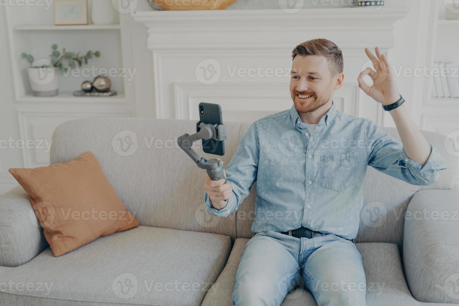 Young man showing thumbs up while video chatting photo