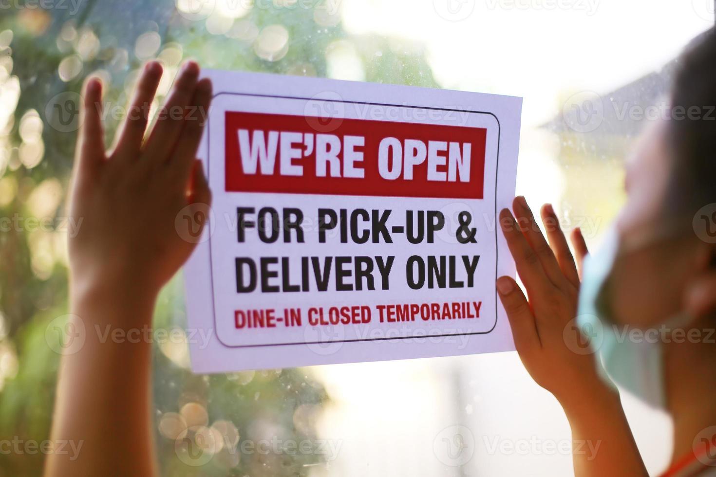 Delivery and take out only notice paper or takeout sign on window door during covid19 outbreak. photo