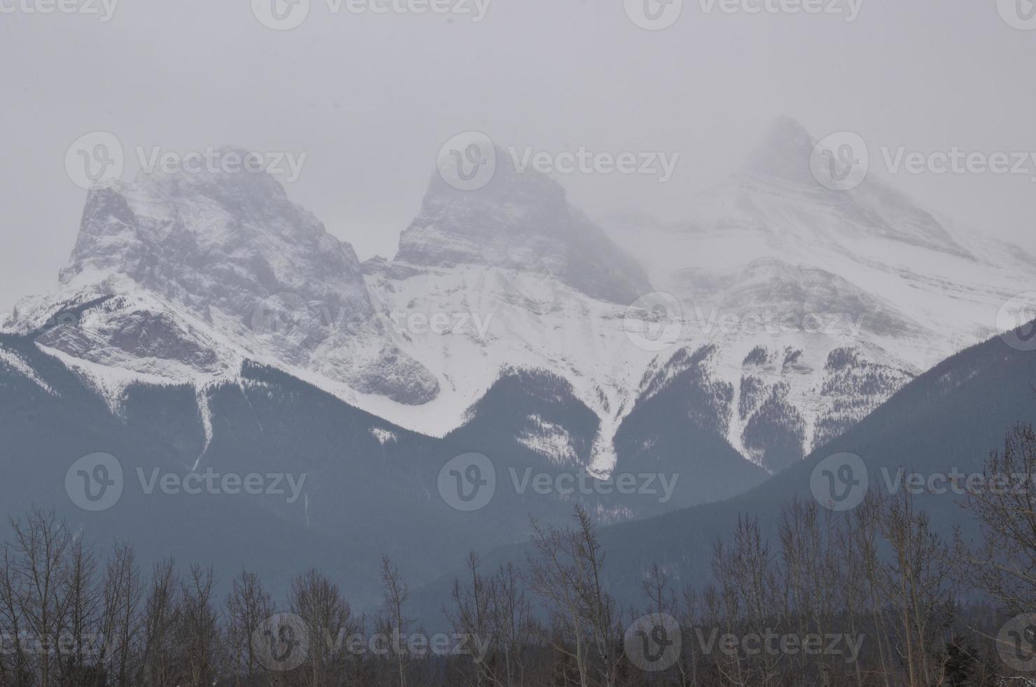 Snow Covered Rocky Mountains with Hazy Grey Sky photo