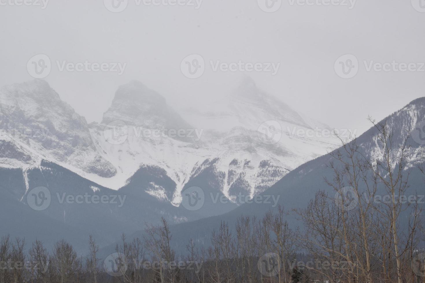 Snow Covered Rocky Mountains with Hazy Grey Sky photo