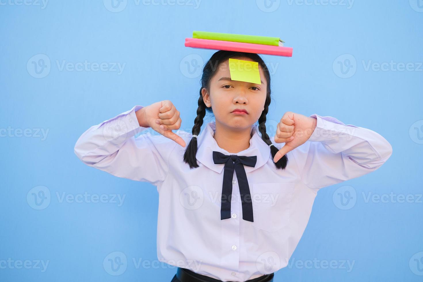 Student with book and small note paper on blue background. photo