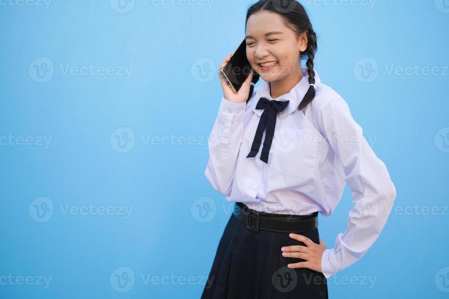Student young girl useing smart phone on blue background. photo