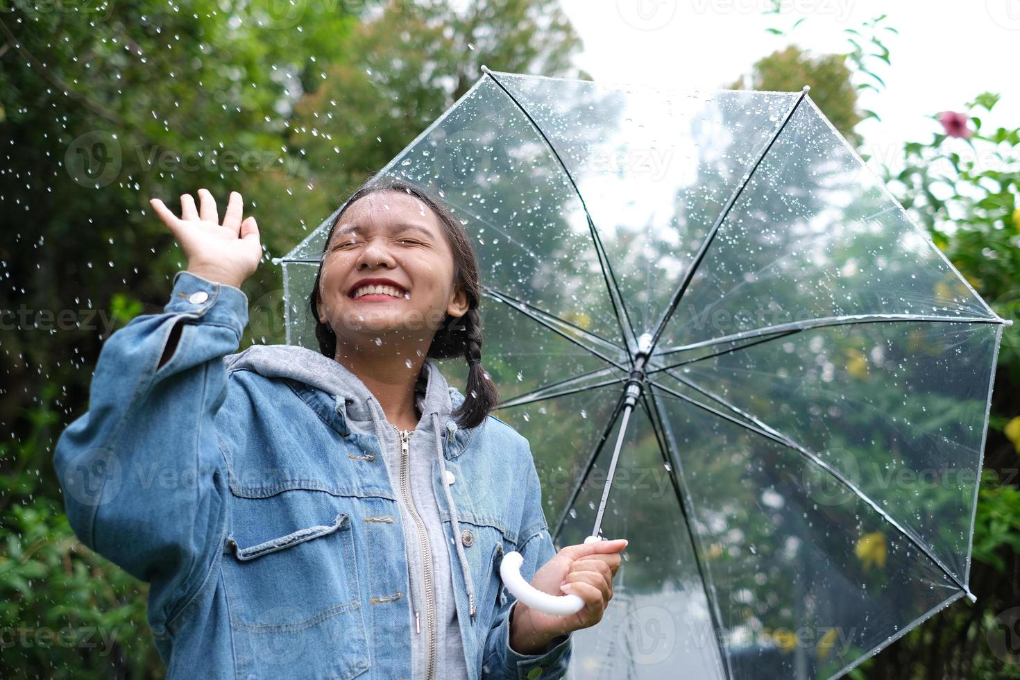 sonrisa joven divirtiéndose en la lluvia. foto