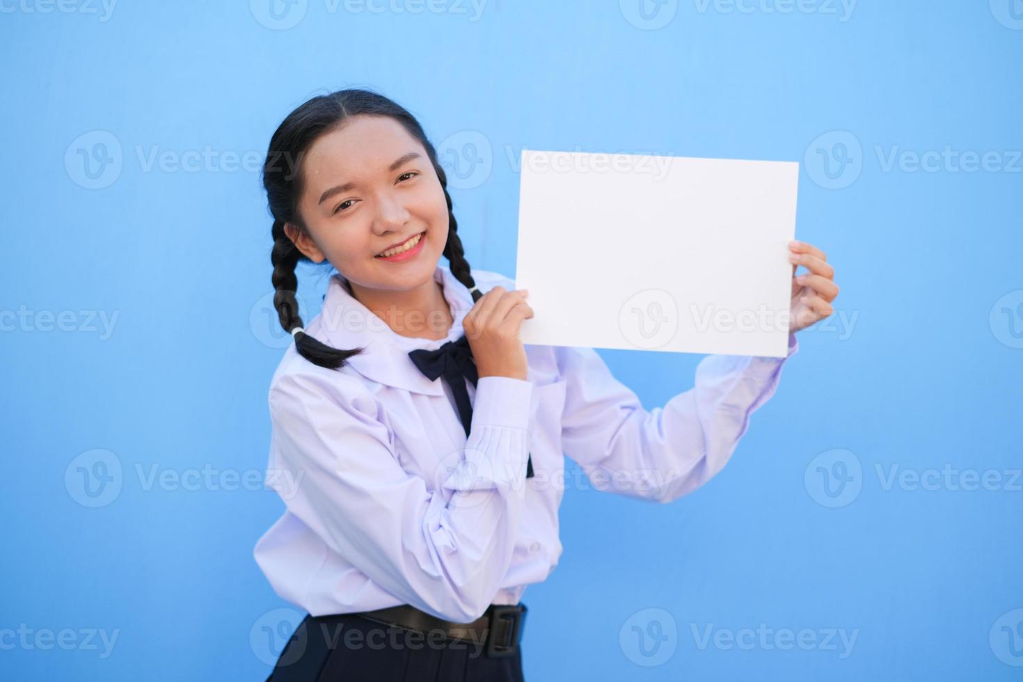 School girl holding billboard on blue background. photo