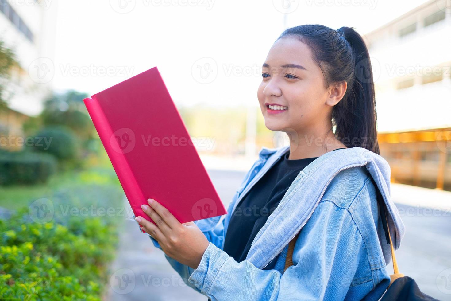 Happy student girl hold book and backpack at school, Asian girl. photo