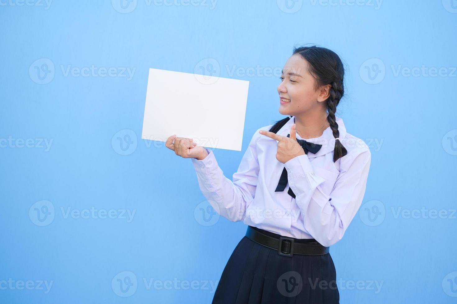 School girl holding billboard on blue background. photo