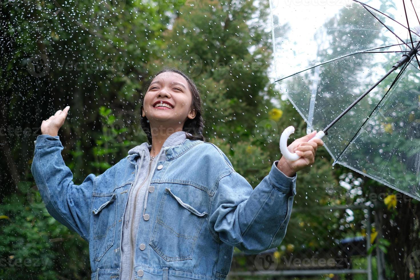 sonrisa joven divirtiéndose en la lluvia. foto