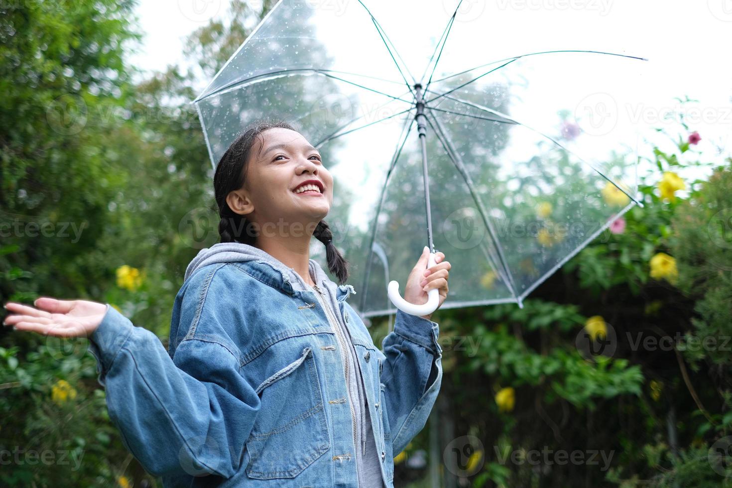 Smile young girl having fun in rainy. photo