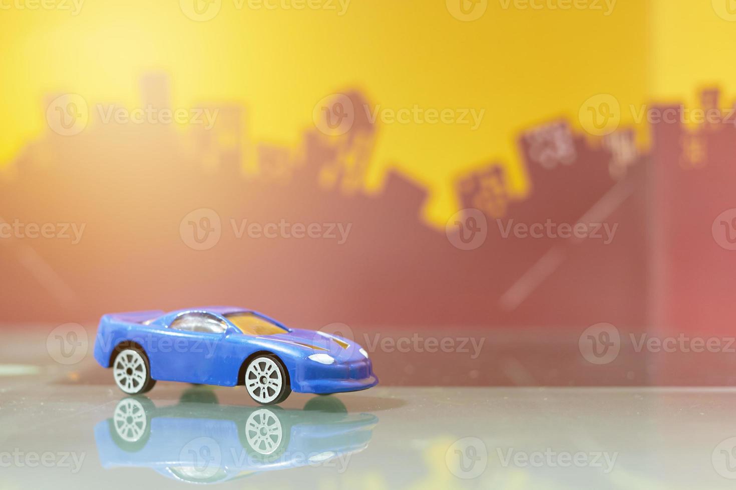 coche sedán azul juguete enfoque selectivo en el fondo de la ciudad borrosa foto