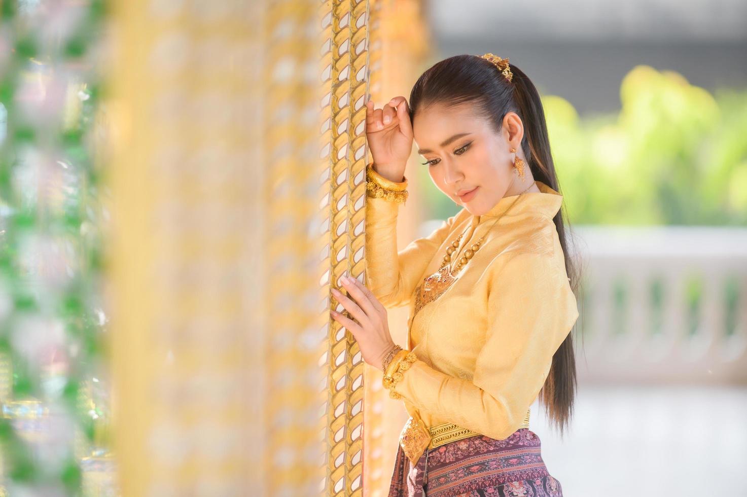 Charming Thai women in traditional Thai costumes prepare to pay homage to the Buddha in a Thai temple to pray for the Songkran tradition in Thailand photo